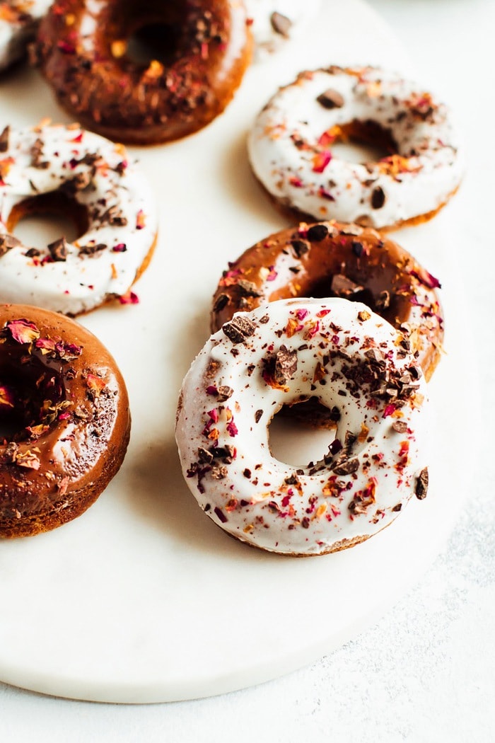 Perfect for Valentine’s Day, these baked almond flour donuts with rose petals and dark chocolate are gluten-free, dairy-free and naturally sweetened with coconut sugar. Baked almond flour donuts topped with chocolate and rose petals.