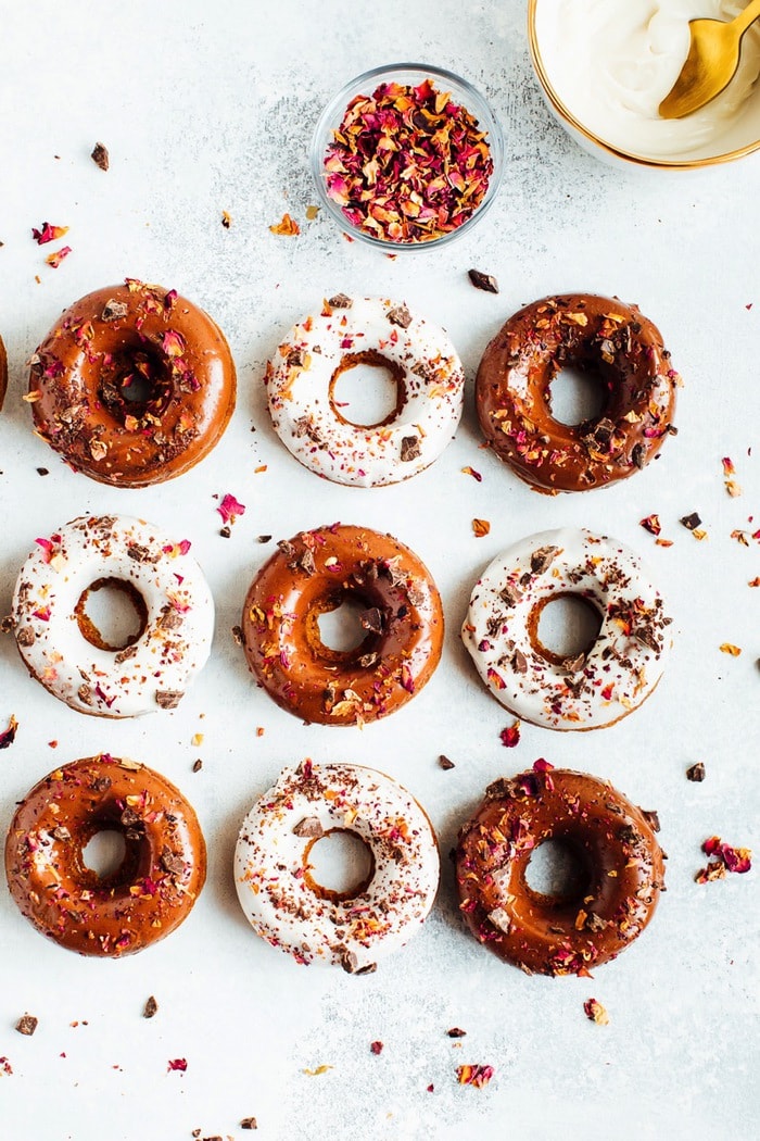 Perfect for Valentine’s Day, these baked almond flour donuts with rose petals and dark chocolate are gluten-free, dairy-free and naturally sweetened with coconut sugar. Baked almond flour donuts garnished with rose petals on a marble counter top.