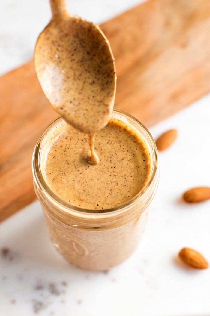 PIN THIS --> Chili Almond Dressing Chili almond dressing in a mason jar with gold spoon.