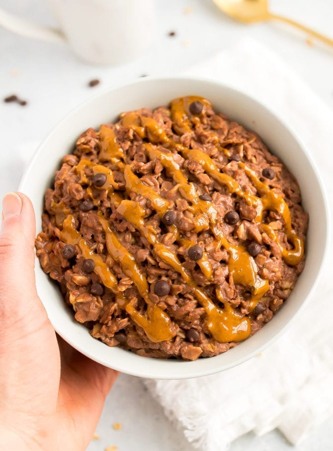 A serving of chocolate peanut butter oatmeal in a bowl topped with peanut butter.