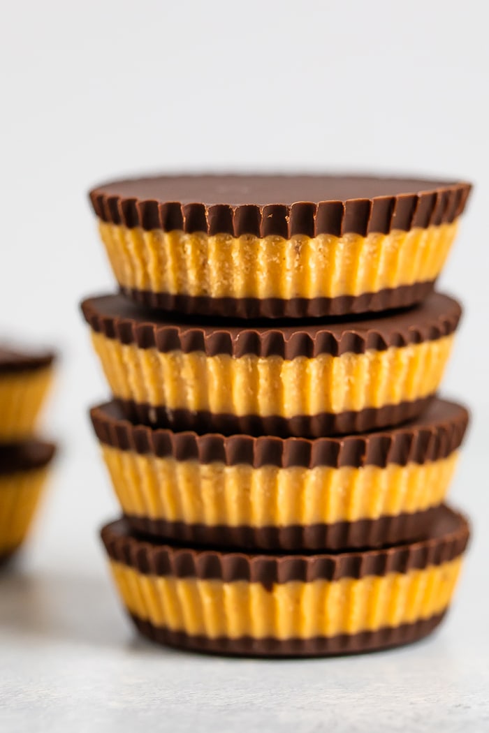 Stack of homemade peanut butter cups with layers of chocolate and peanut butter filling.