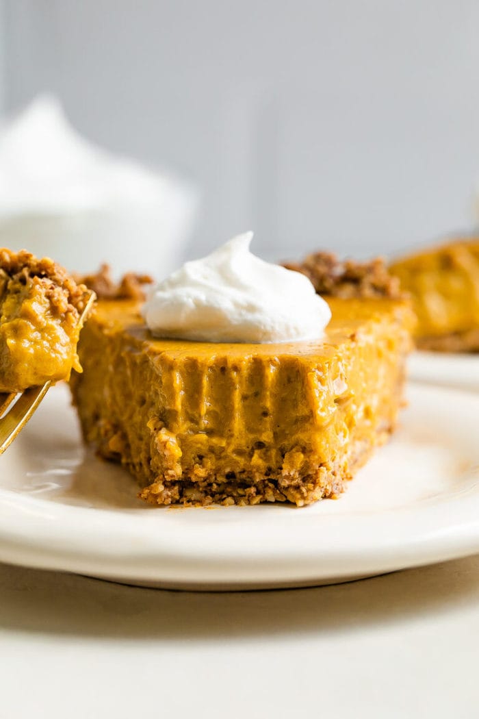 Slice of vegan pumpkin pie topped with whipped cream.