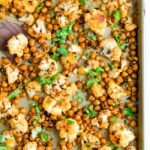 Roasted cauliflower and chickpeas on a sheet pan topped with cilantro.