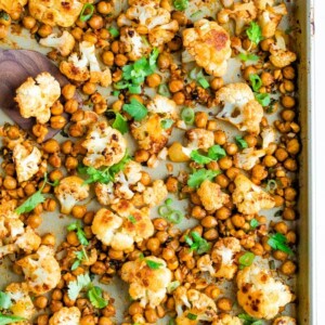 Roasted cauliflower and chickpeas on a sheet pan topped with cilantro.