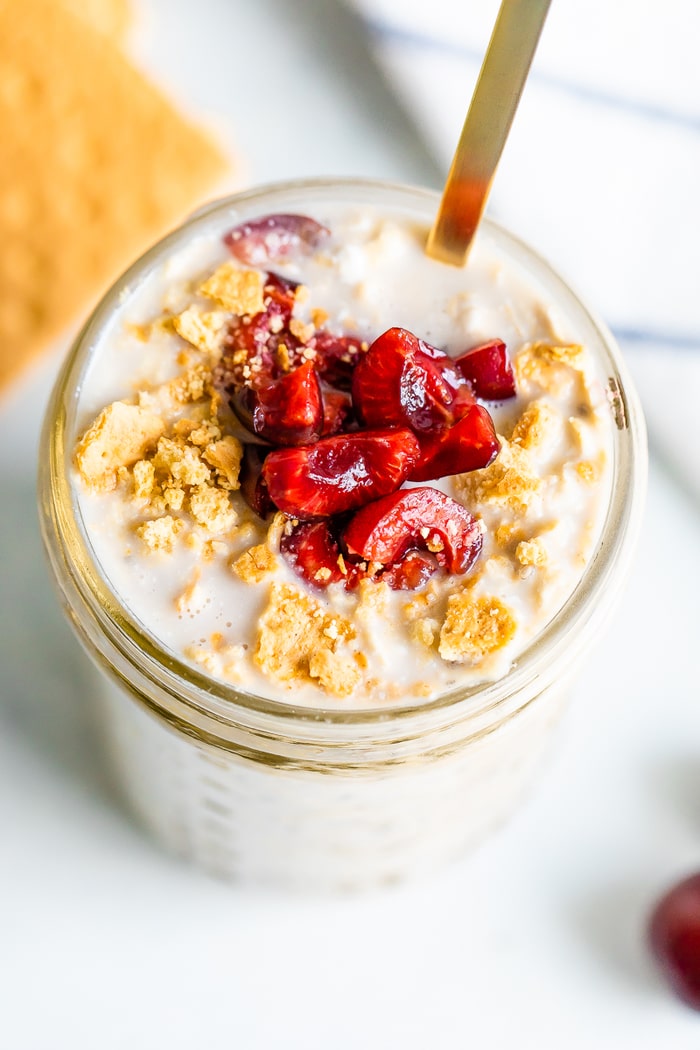 Overhead photo of cherry cheesecake overnight oats in a mason jar.