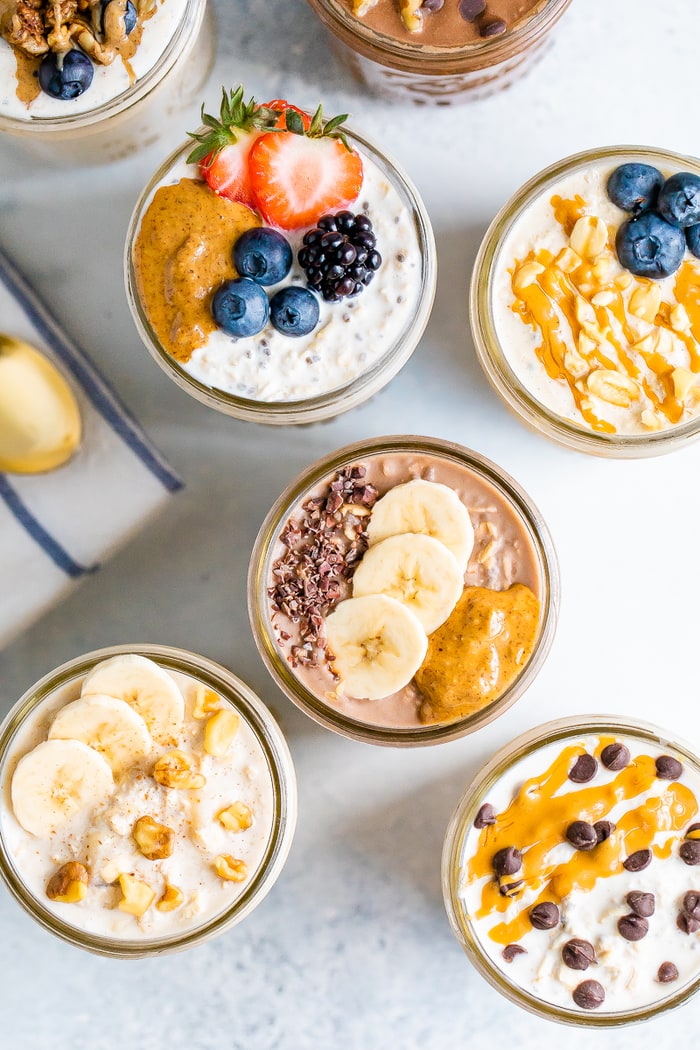 Overhead photo with 7 jars of overnight oats, each with different toppings.