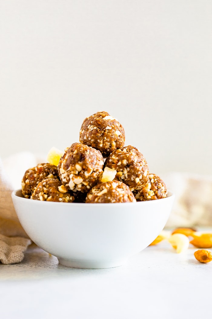 Straight on photo of a white bowl with gingerbread energy balls.