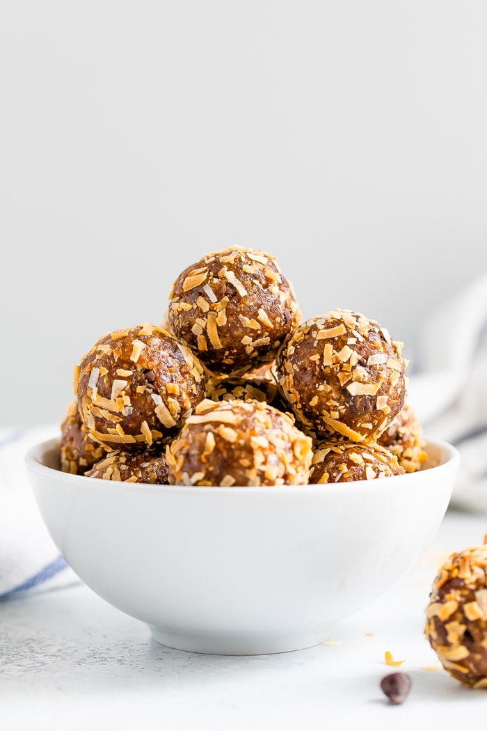 Straight on photo of samoa energy balls in a white bowl.