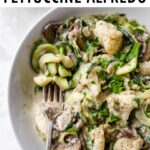 Fork on a plate of zucchini noodle alfredo.