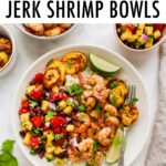Plate with rice, pineapple salsa, jerk shrimp and plantains with lime and cilantro for garnish.