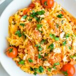 A plate of spaghetti squash with feta, basil and tomatoes.