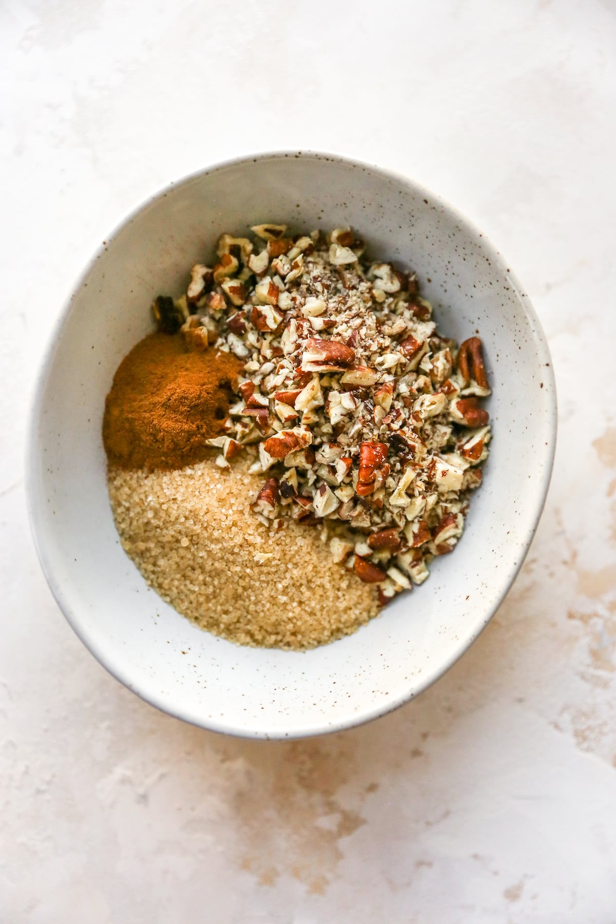 Bowl of cinnamon, sugar and pecans.