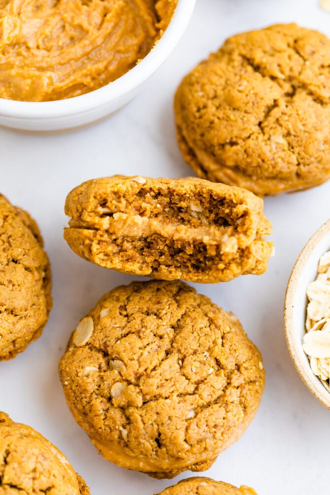 Homemade peanut butter sandwich cookies and one has a bite taken out of it.
