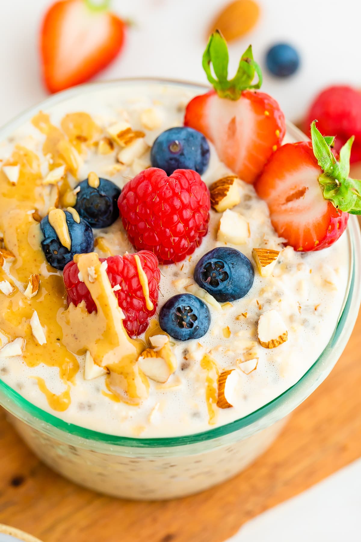 A serving of protein overnight oats topped with fresh berries, crushed almonds, and a drizzle of nut butter.