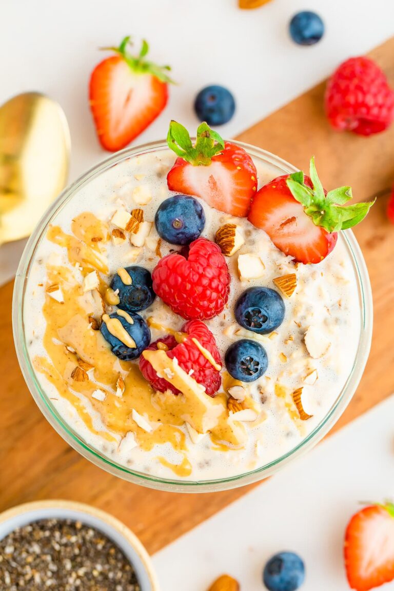 A jar of protein overnight oats topped with berries, almonds and peanut butter.