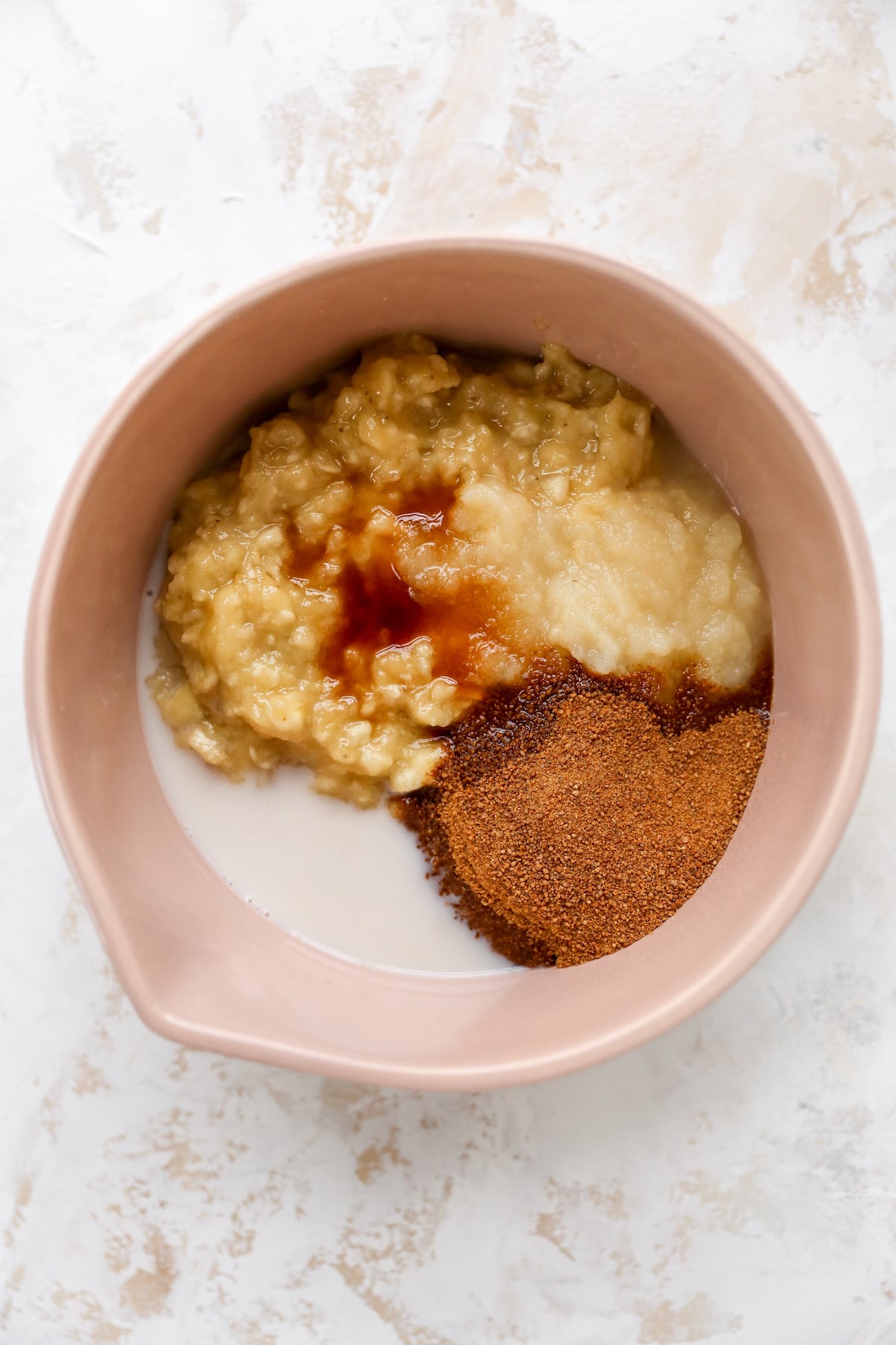 Mixing bowl with banana bread batter ingredients before being mixed.