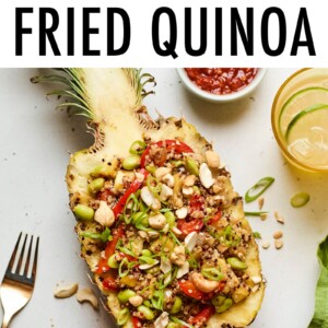 Pineapple boat full of pineapple fried quinoa. Bowl of garlic chili sauce is next to the pineapple.