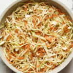 A large serving bowl of vinegar coleslaw.
