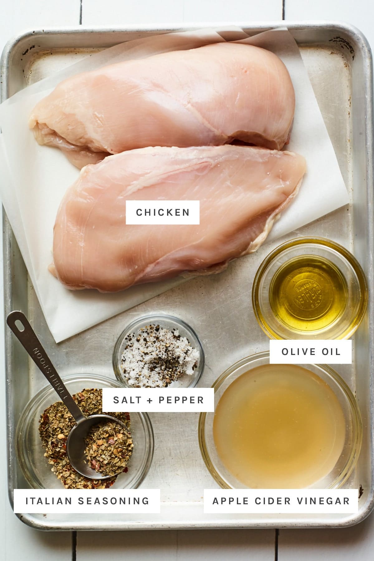 Chicken, olive oil, italian seasoning, vinegar and salt and pepper measured out.