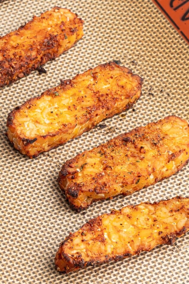 Blackened Tempeh Slices of baked blackened tempeh on a sheet pan.