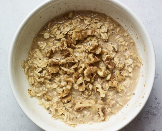 Mixing bowl with mixture to make banana walnut baked oatmeal.