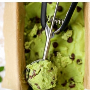 Ice cream scooper with a scoop of mint chocolate chip avocado ice cream.