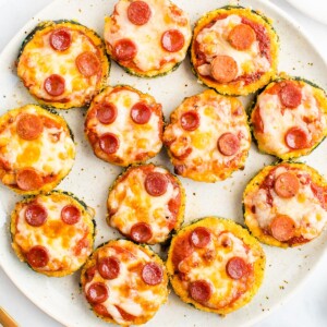 Zucchini pepperoni pizza bites on a plate.