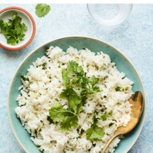 Bowl of cilantro rice with a serving spoon.