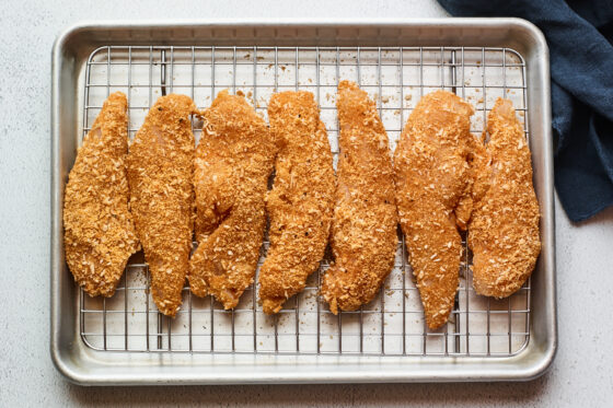 Chicken tenders on a cooling rack.