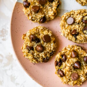 Five oatmeal banana chocolate chip cookies served on a plate.