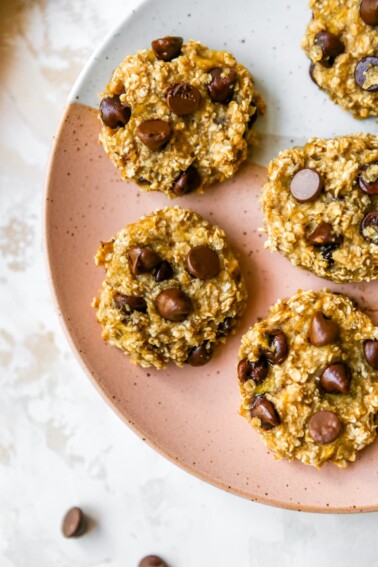Five oatmeal banana chocolate chip cookies served on a plate.