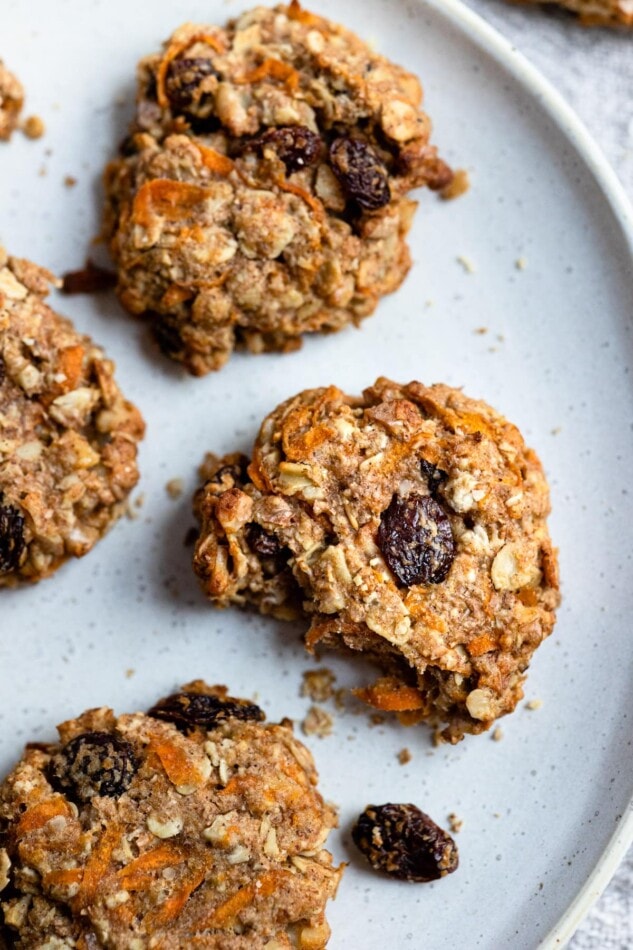 An over-head photo of a plate of carrot cake breakfast cookies. One of the cookies had a bite taken from it.