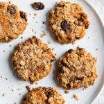 Five carrot cake breakfast cookies being served on a large white plate.
