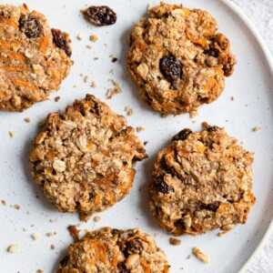 Five carrot cake breakfast cookies being served on a large white plate.