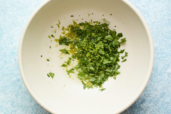 A large bowl with chopped cilantro, lime juice, and lime zest.