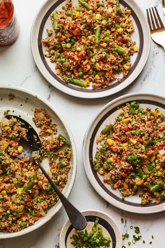 Save this delicious Shrimp Fried Quinoa recipe! Overhead photo of two plates of quinoa fried rice with a serving bowl of additional quinoa fried rice next to them.