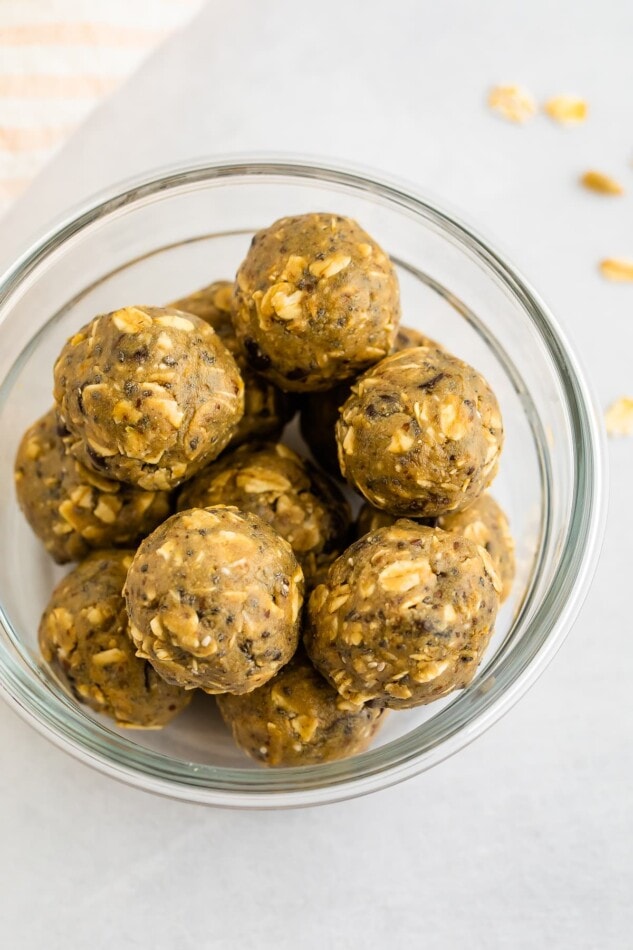 Made with sunbutter, flaxseed, hemp seeds, raisins, chocolate chips and a splash of maple syrup these healthy bites are packed with flavor, kid-approved and nut-free so they're safe for school! Sunbutter energy bites in a glass meal prep storage container.