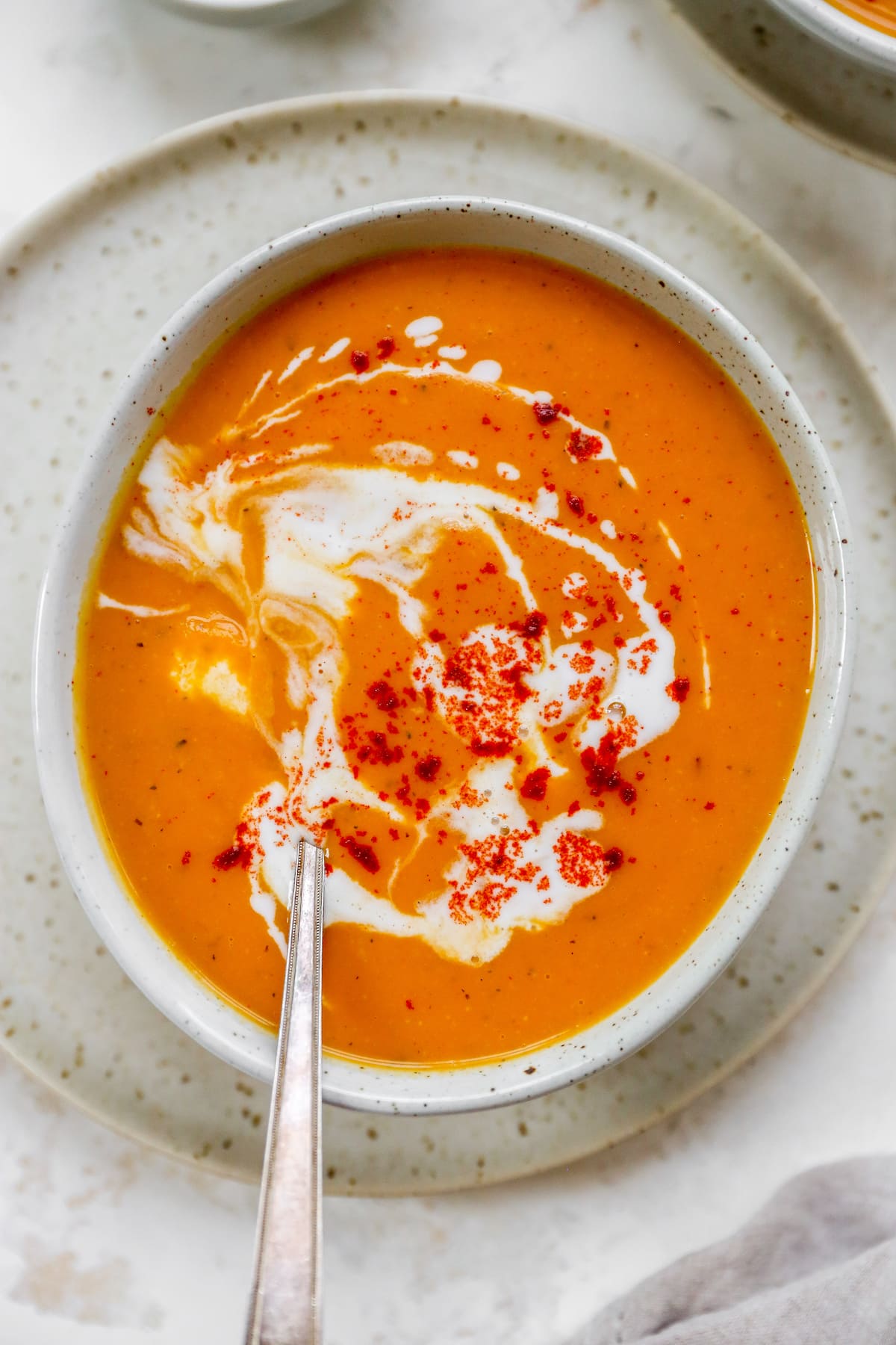 The best VEGAN Curried Sweet Potato Soup // Flavored with traditional curry spices and made creamy with coconut milk. Overhead photo of a bowl of soup with a spoon resting inside the bowl.