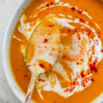 An overhead photo of a spoon ladling out some soup from a bowl.