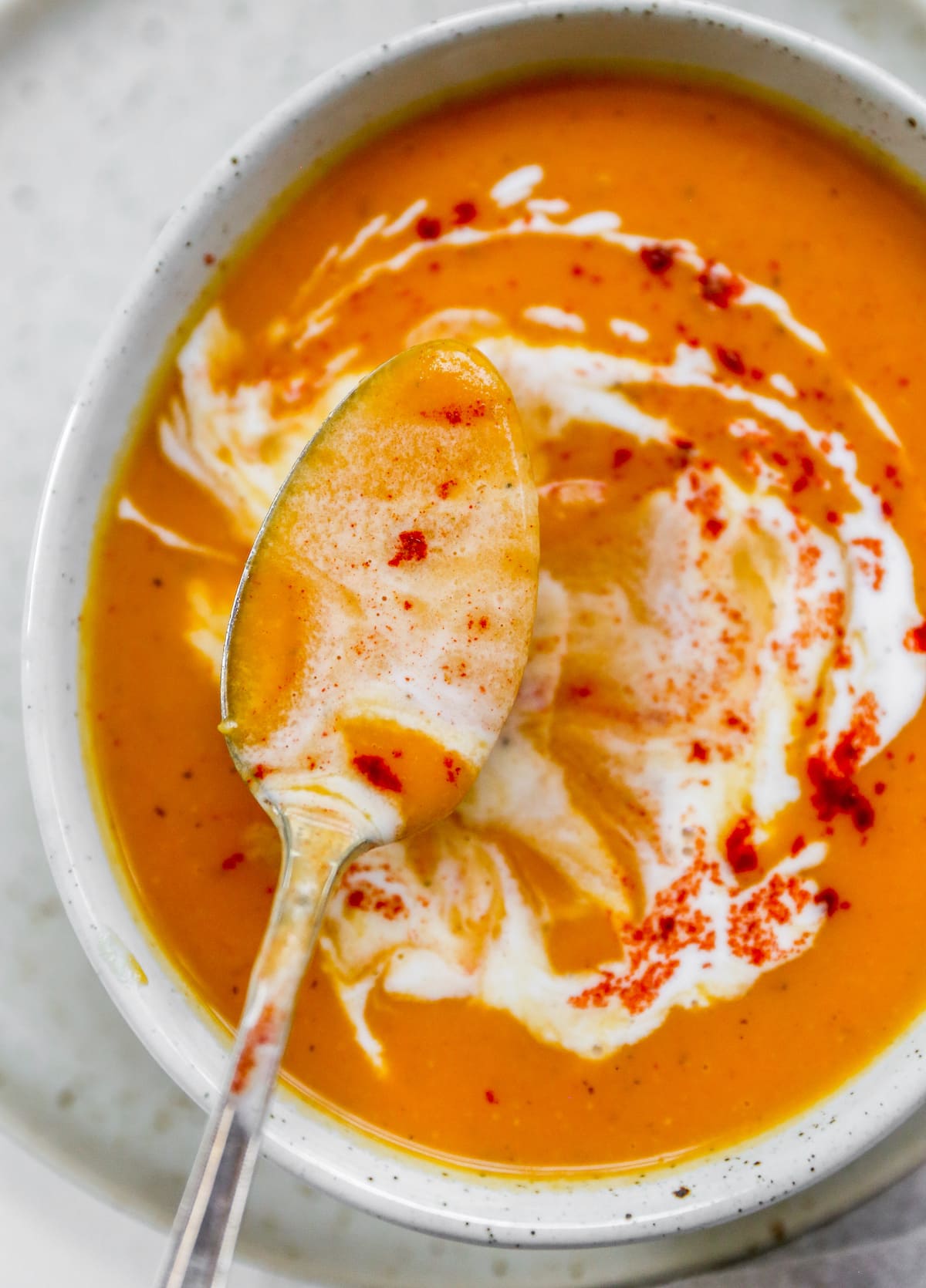 An overhead photo of a spoon ladling out some soup from a bowl.
