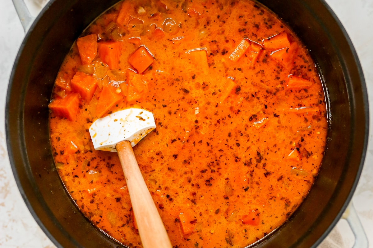 Overhead photo of a pot of soup with a spatula resting inside the pot.