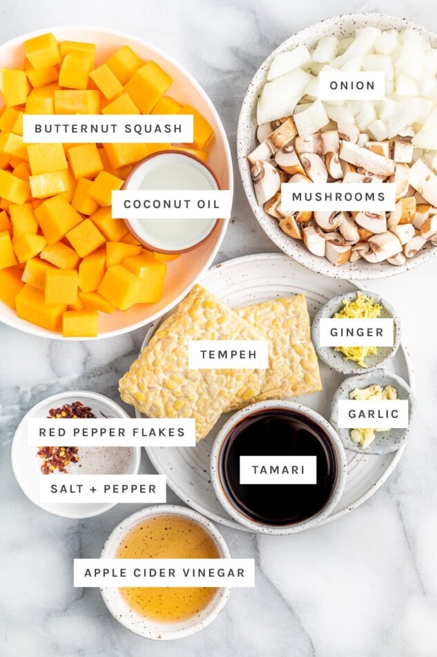 This tempeh butternut squash bake is loaded with protein, veggies and flavor! It's easy to make, vegan, gluten-free and absolutely delicious! Ingredients measured out to make a tempeh butternut squash bake: butternut squash, coconut oil, onion, mushrooms, tempeh, ginger, garlic, tamari, red pepper, salt and vinegar.