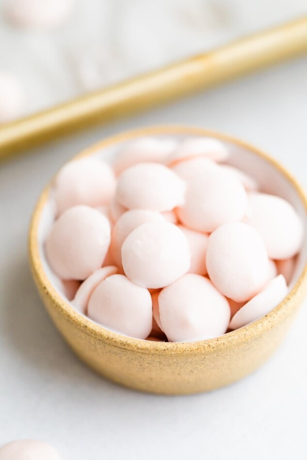 A small bowl with frozen pink baby yogurt melts inside.
