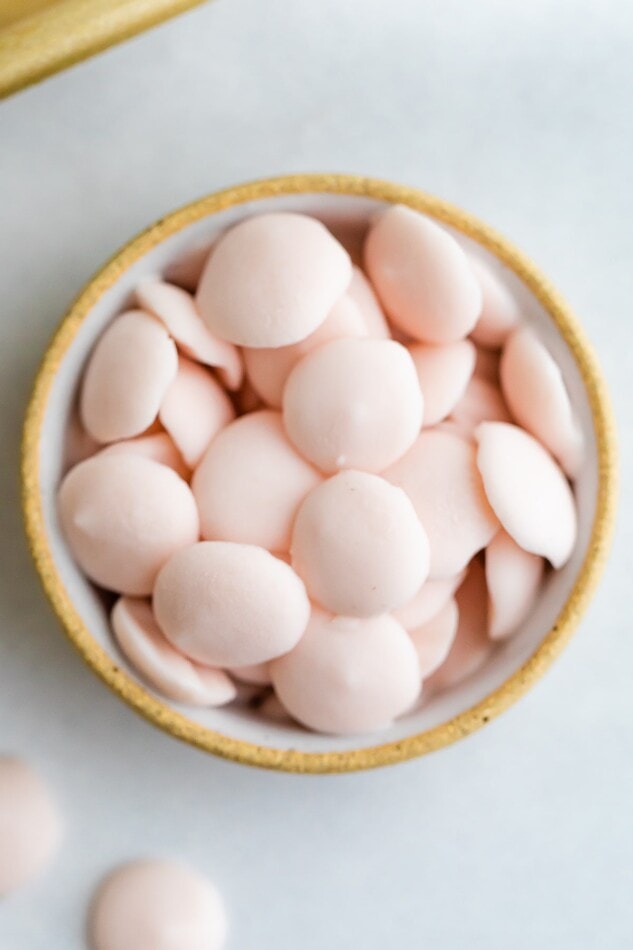 A small bowl full of pink frozen yogurt melts.