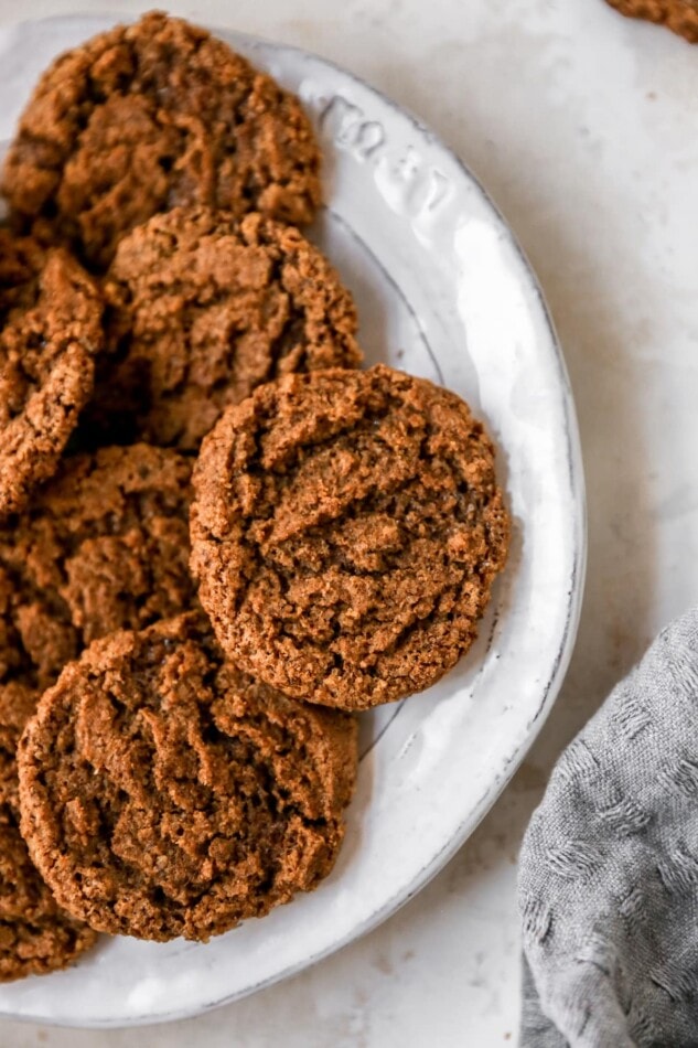 Crunchy and chewy, these almond butter espresso cookies are made with one bowl and only six ingredients. Plus, they're flourless, vegan and gluten-free! An overhead photo of a plate containing almond butter espresso cookies.