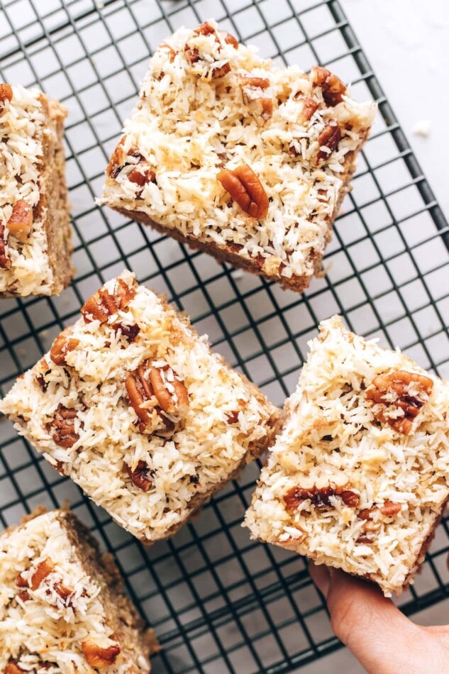 Pin this image to save the recipe for these delish Old Fashioned Oatmeal Cupcakes! An overhead photo of 3 squares of oatmeal cake on a wire cooling rack.