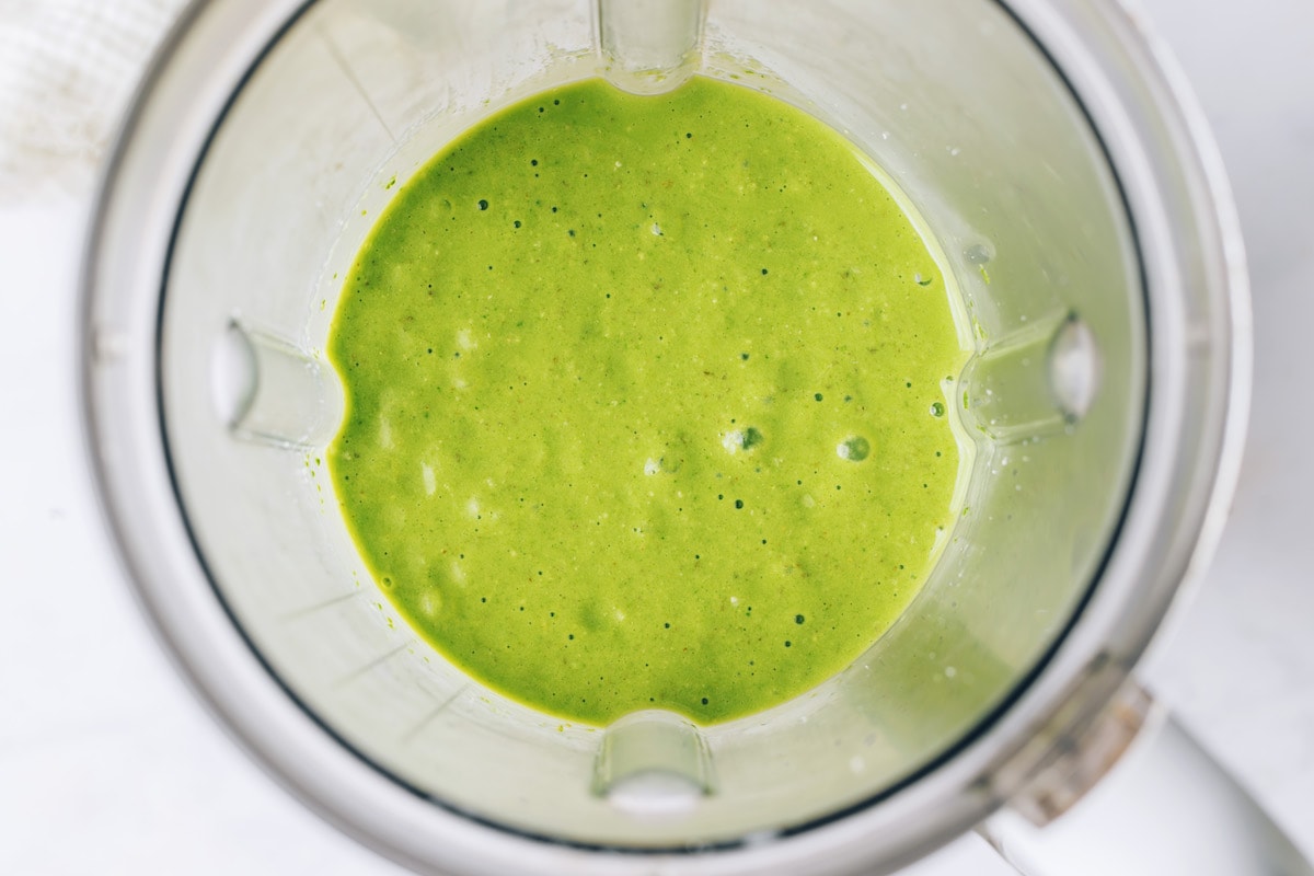 Ingredients for green protein smoothie blended together in a high powered blender.