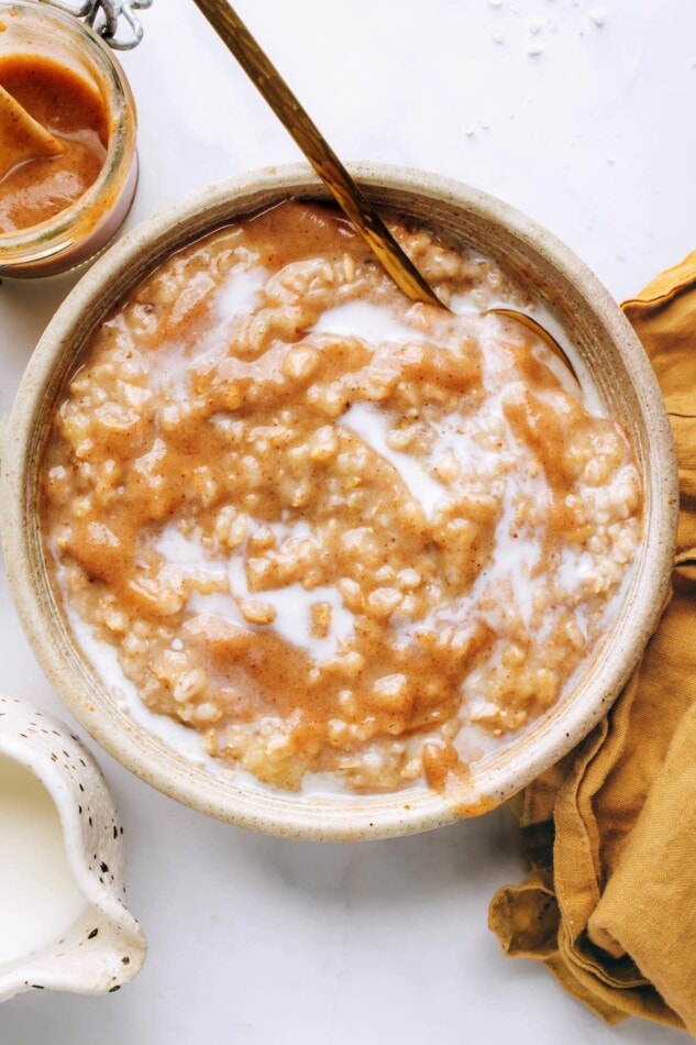 An overhead photo looking at a bowl of salted caramel oatmeal. A spoon rests in the bowl.