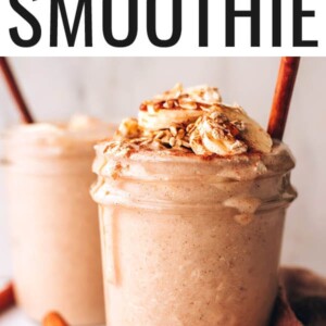 Mason jar filled with an oatmeal smoothie, topped with cinnamon, banana and oats.