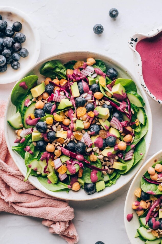 Antioxidant Salad with Blueberry Tahini Dressing #vegan #healthy #plantbased An overhead photo looking down at a bowl of spinach blueberry salad.